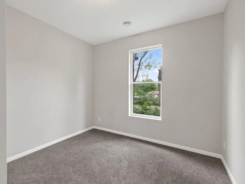 Carpeted bedroom with a single window