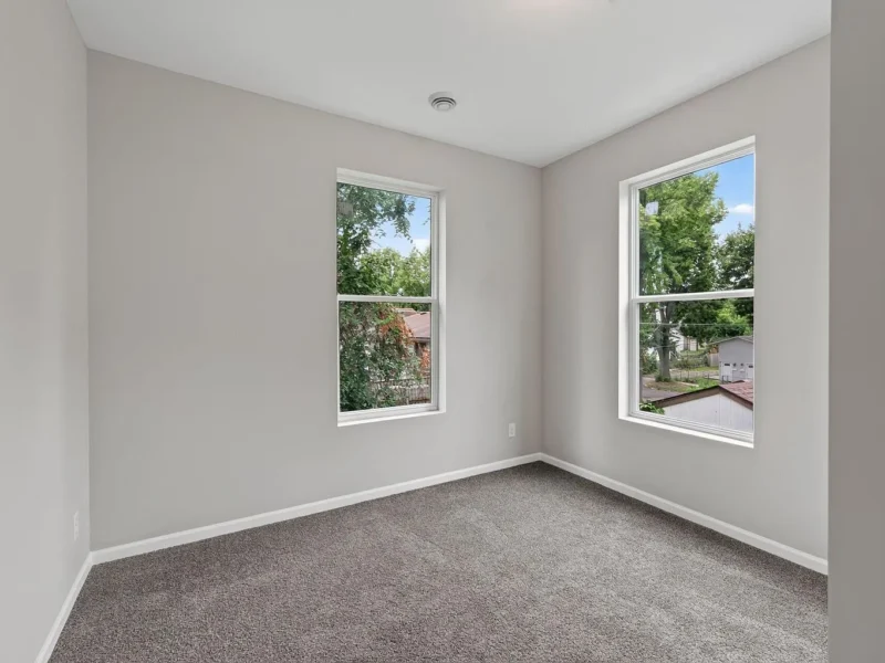 Carpeted bedroom with windows on two walls
