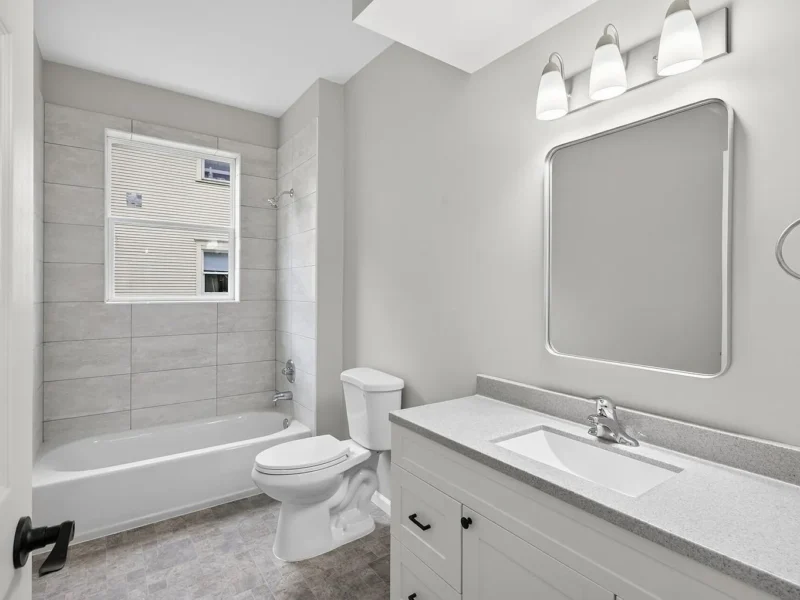 Bathroom with a vanity, mirror and tiled tub