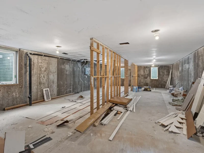 Unfinished lower level with framing and egress windows