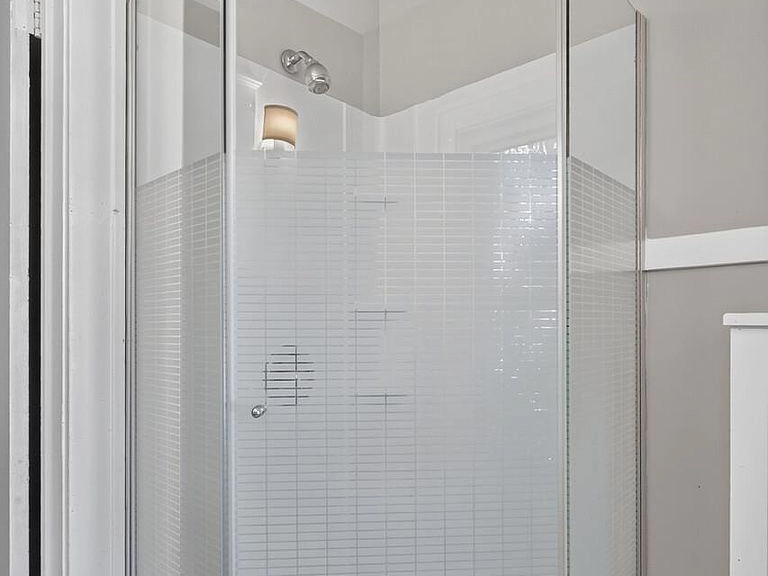 Tiled corner shower with a glass enclosure