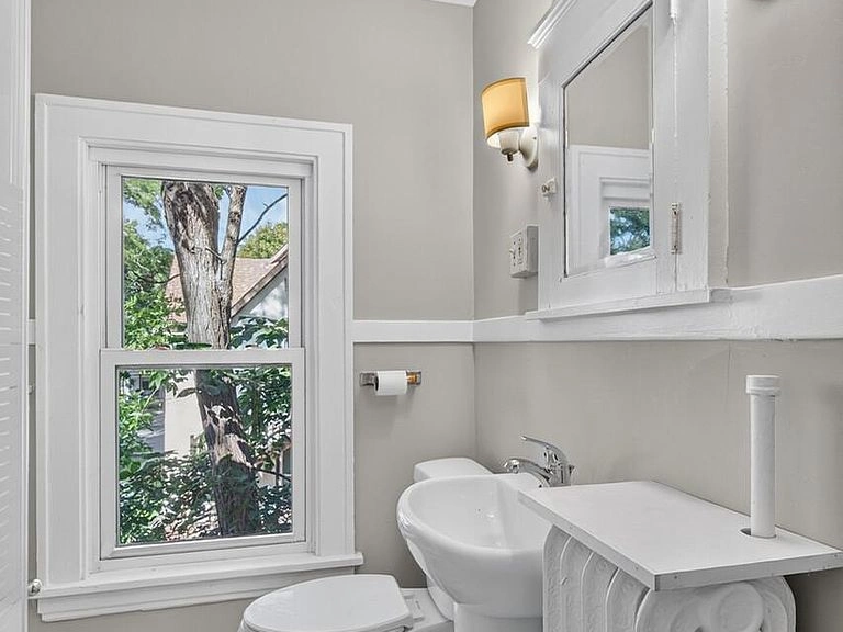 Bathroom with a pedestal sink, window and radiator