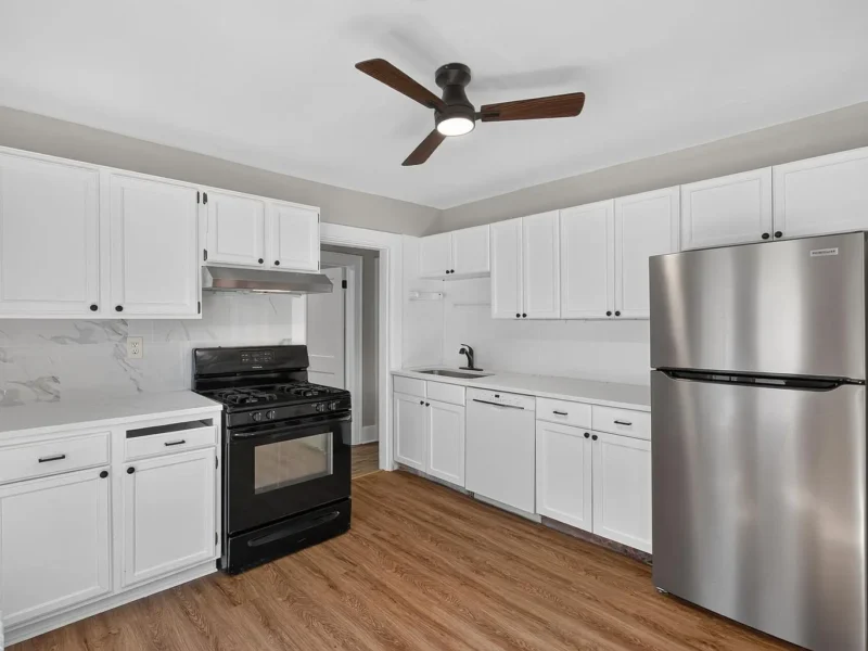 Kitchen with white cabinetry, a gas range and a stainless refrigerator