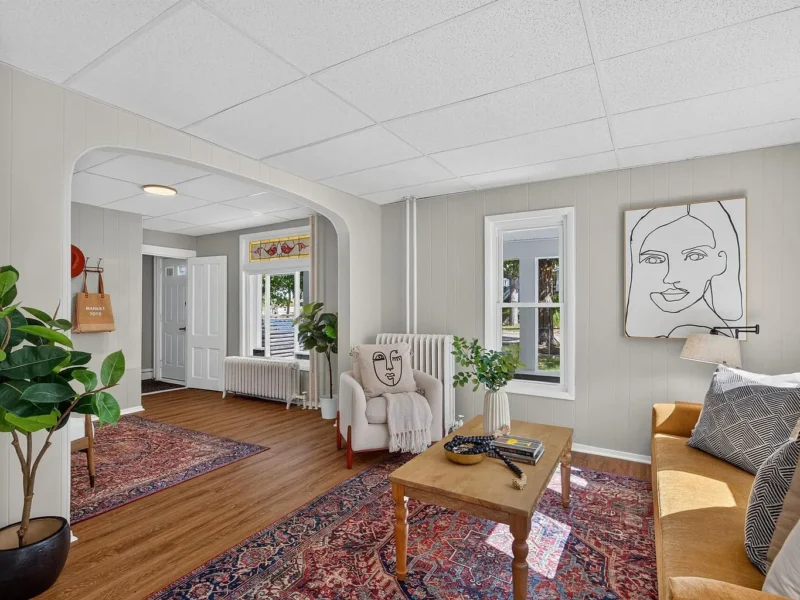 Living room with a radiator, windows and an arched doorway