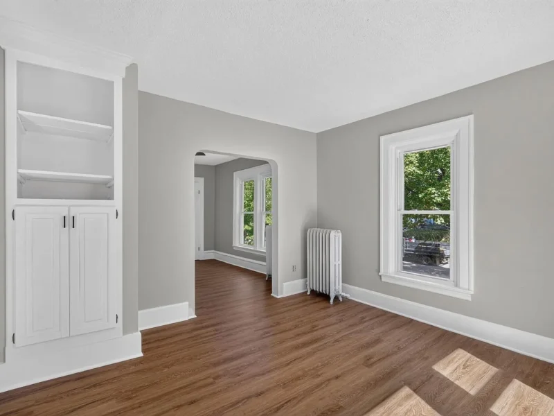 Room with built-in shelving beside an arched opening