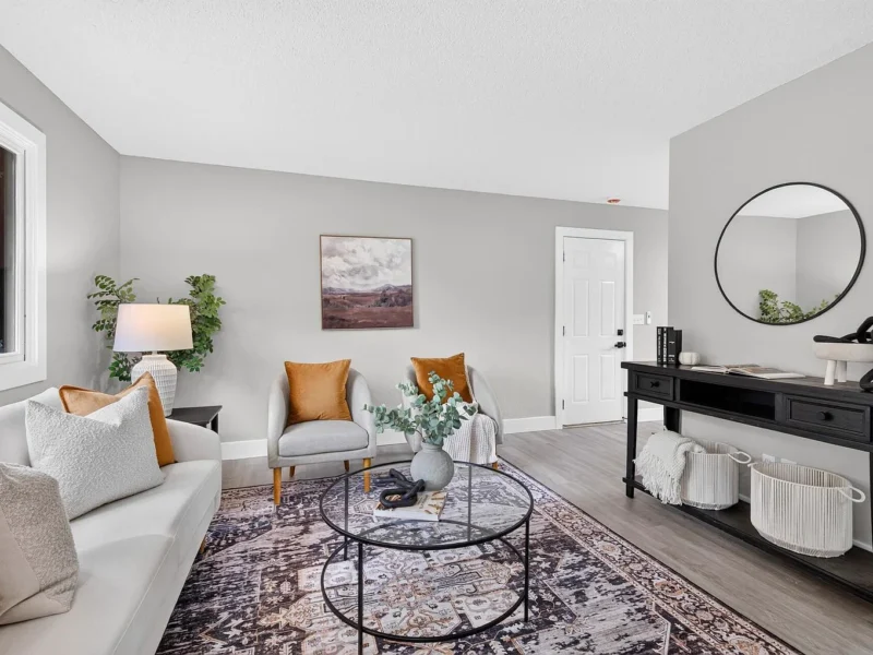Living room with a console table and a round mirror beside the front door