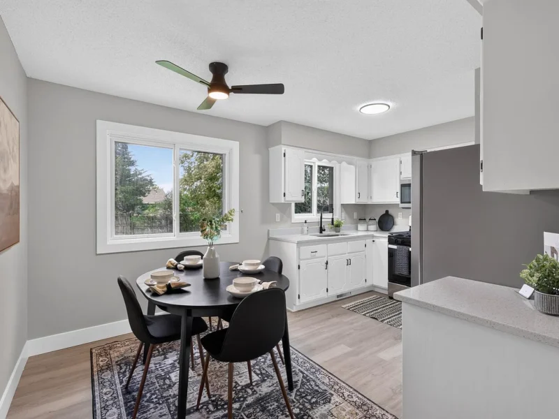 Dining area with a round black table, open to the kitchen
