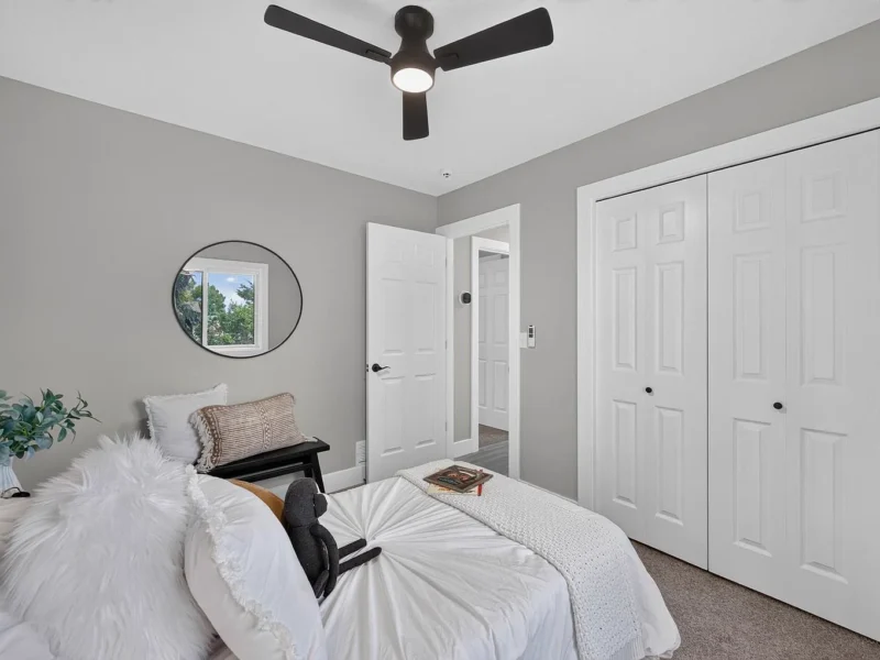 Bedroom with a ceiling fan and white double closet doors