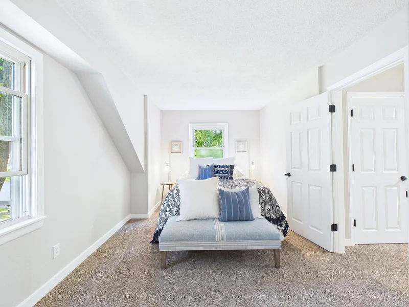 Upstairs bedroom with two windows and carpet