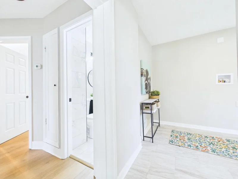 Hallway with a mirror and doors to the bedrooms