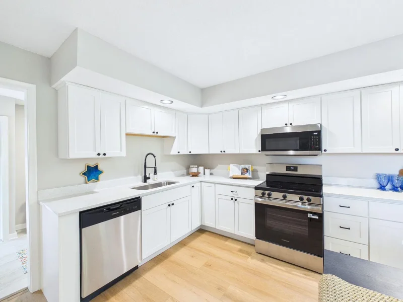 Kitchen with white cabinets, quartz counters and a gas range