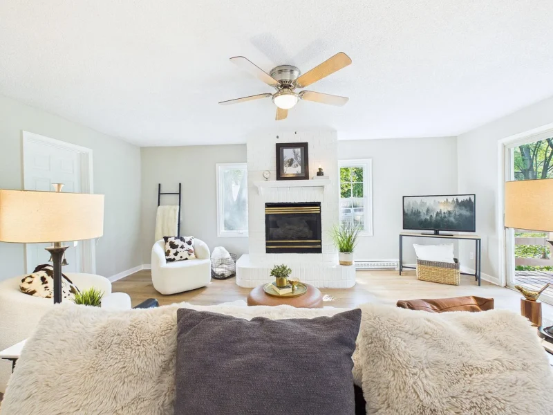 Living room with a white brick fireplace and a ceiling fan