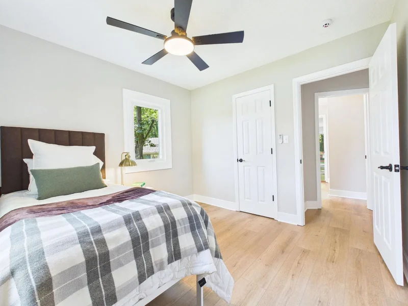 Bedroom with wood-look flooring and two windows