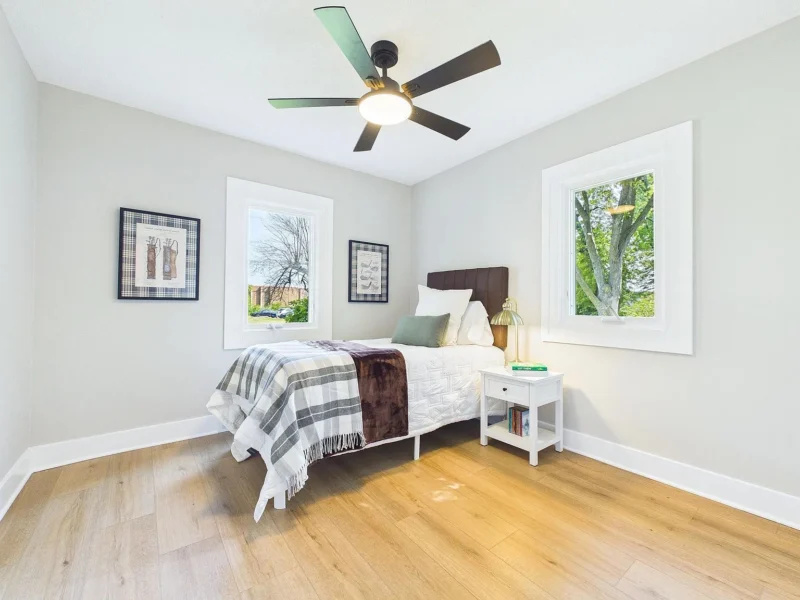 Bedroom with a ceiling fan and two windows